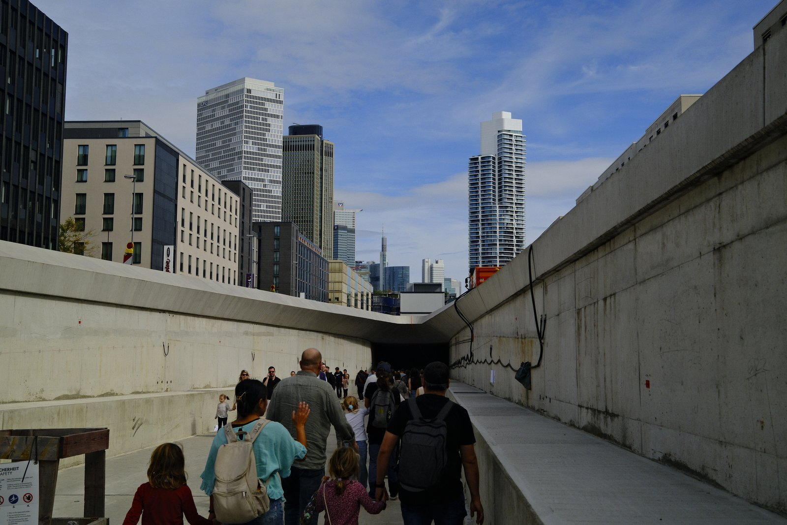 Visitors walking down the entry ramp, Frankfurt skyline behind
