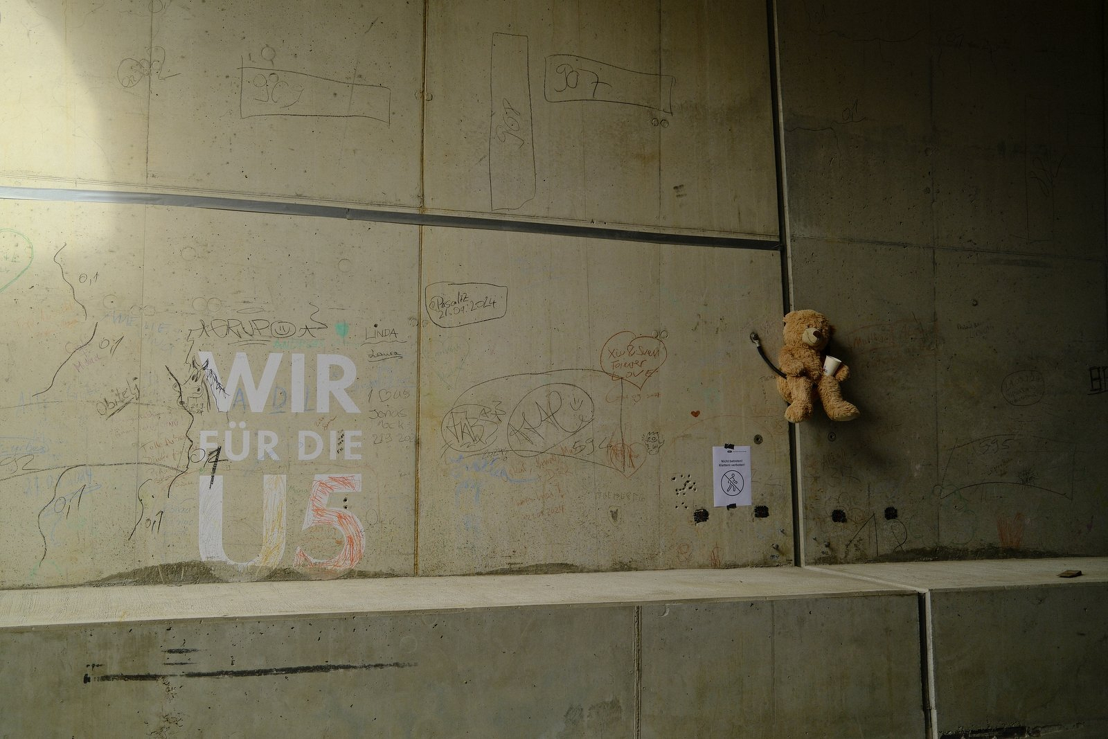 Concrete wall with a teddy bear and the words WIR FÜR DIE U5