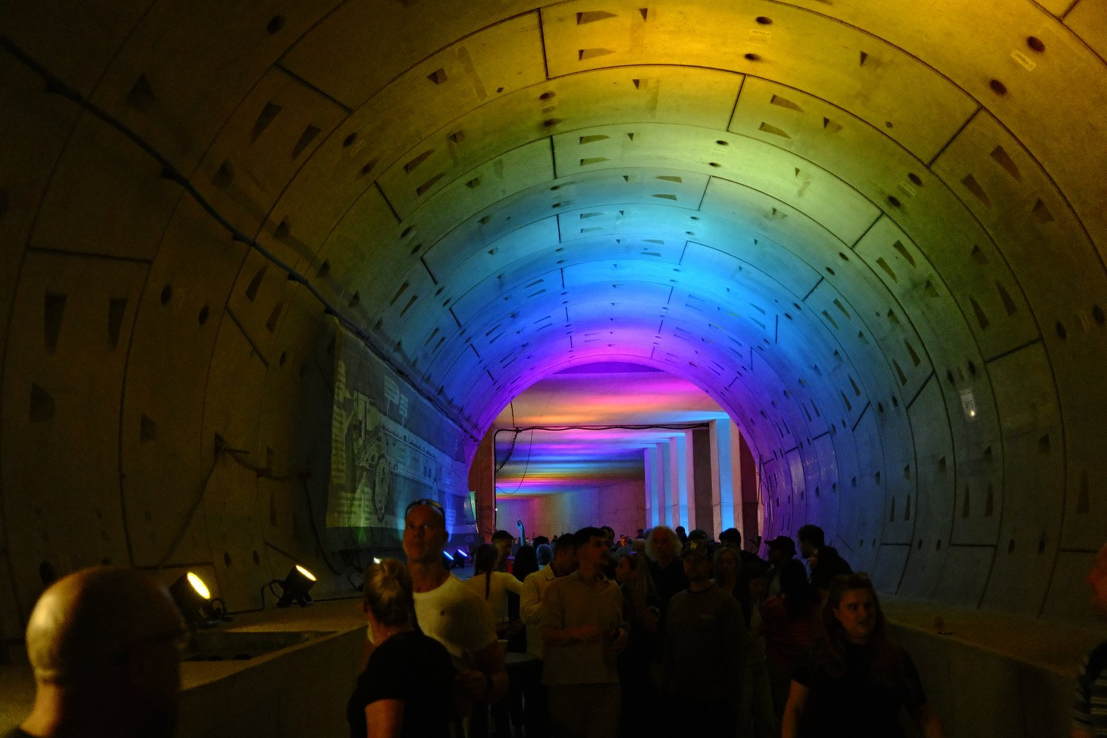 Rainbow light along a curved concrete tunnel