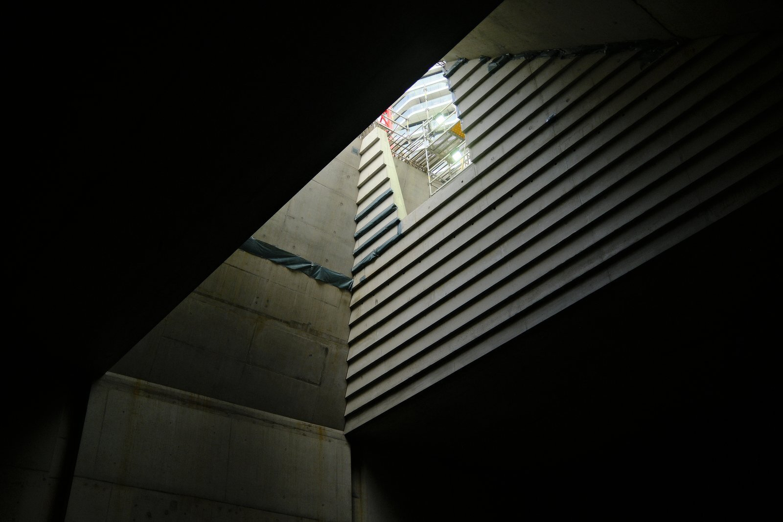 Looking up a concrete shaft to daylight and scaffolding